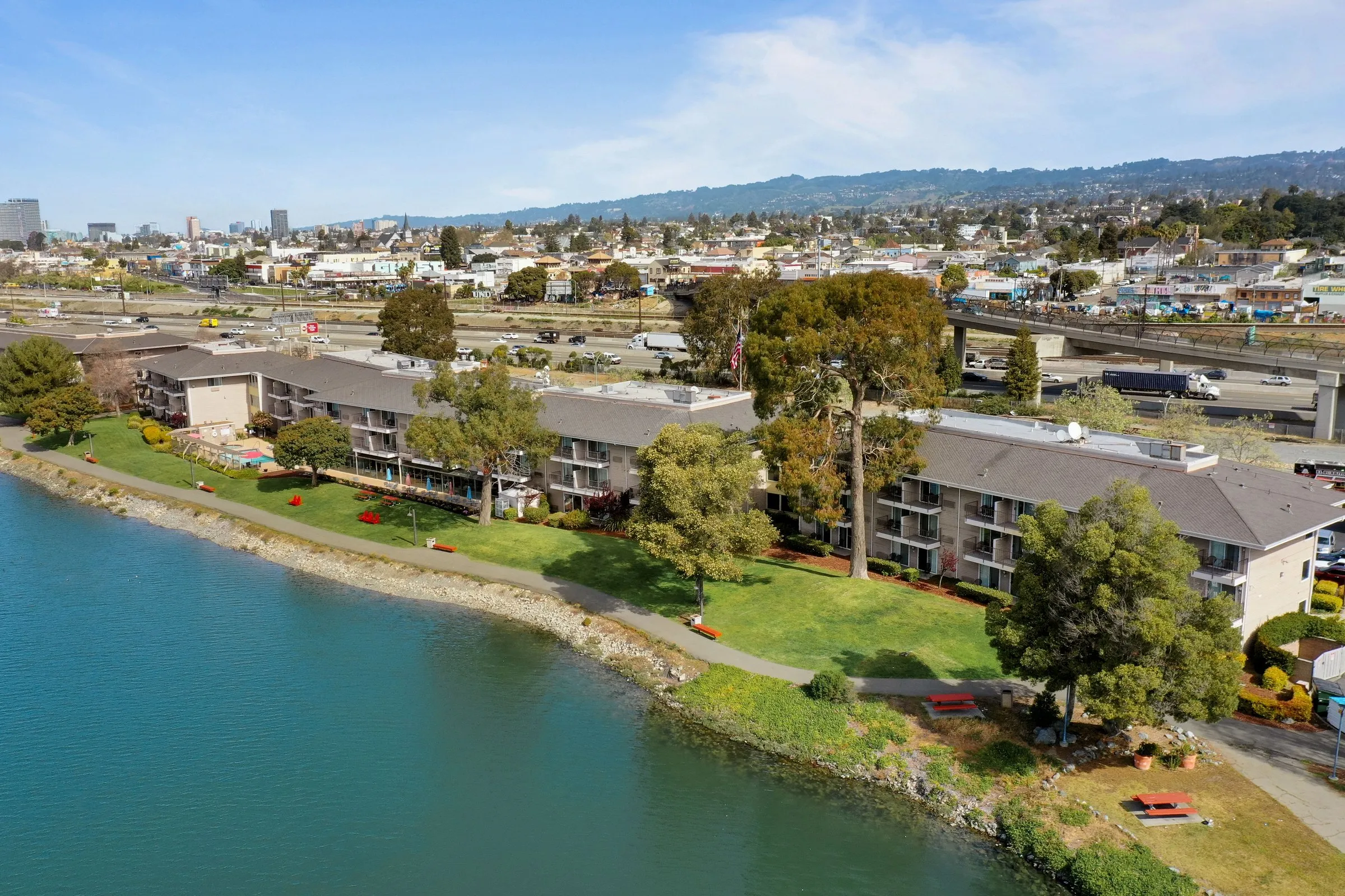 Aerial photograph of Executive Inn & Suites on the edge of the Oakland estuary, with the Oakland hills behind